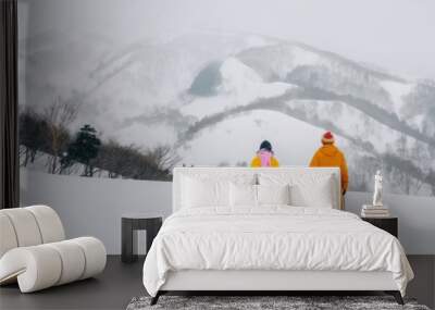 A family is having a great time on a winter vacation in the snowy mountains during the holiday season, enjoying the beautiful landscapes and making unforgettable memories together Wall mural