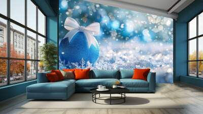 A festive blue ornament with a bow brings holiday magic to the winter landscape, adding a touch of celebration and elegance to the snowy scenery, enhancing the joy and beauty of the season Wall mural