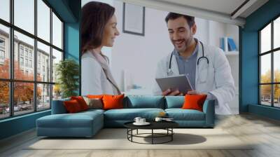 In a medical office setting, a doctor is seen utilizing a digital tablet during a consultation with a patient, exemplifying the incorporation of technology in modern healthcare and medicine Wall mural