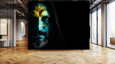 Brutal man with a gray beard in the hood with sharp shadows on a black background. Copy space. Wall mural