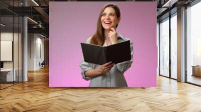 happy teacher or student woman holding book and looking up, isolated portrait. Wall mural