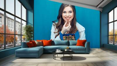 Happy young woman eating chocolate candies. Wall mural