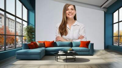 Isolated portrait of smiling business woman in white shirt standing with arms crossed. Wall mural