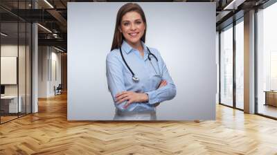 Portrait of smiling female medical worker with folded hands. Wall mural