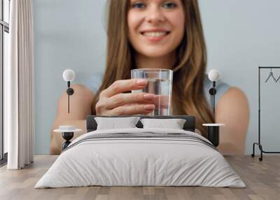 smilinf woman holding water glass in front of. Wall mural