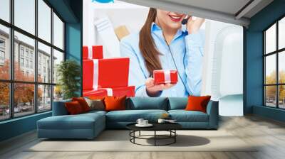 Smiling operator seat at table with red gift box. Happy busines Wall mural