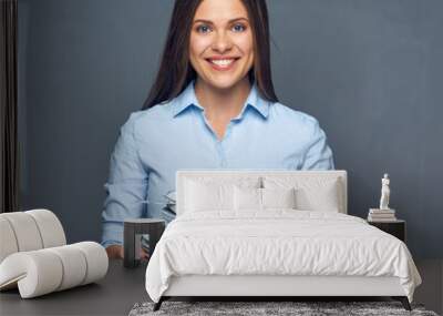 Smiling woman holding stack of plate with kife and fork Wall mural