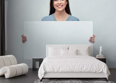 Smiling woman holding white advertising board with empty copy sp Wall mural