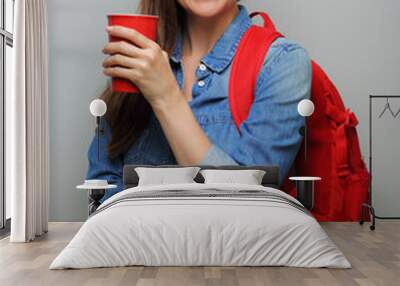 Smiling woman student with red backpack and coffee glass. isolated female portrait. Wall mural