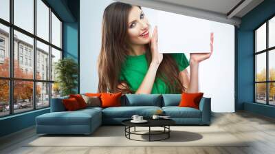 Teenager girl hold white blank paper. Young smiling woman show Wall mural