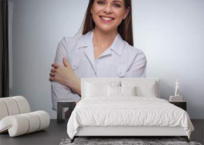 woman doctor wearing white medical uniform standing with crossed arms. Wall mural