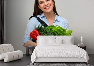 Woman holding shopping bag with vegetables and greenery. Wall mural