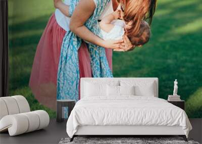 woman small infant plays outside park meadow Wall mural