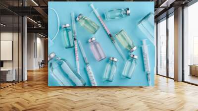 Diverse vaccine vials on blue Wall mural