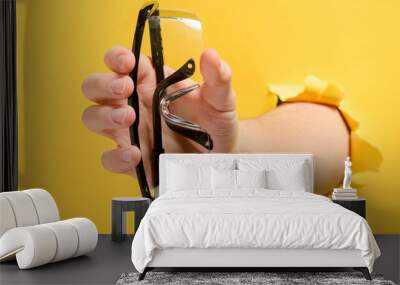 Hand holding safety glasses Wall mural