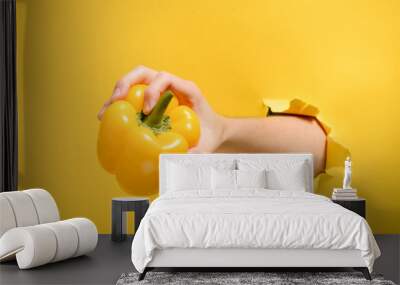 Hand taking a yellow pepper Wall mural