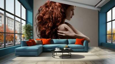 Beautiful woman with curly hairstyle against gray background Wall mural