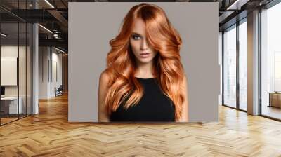 Beautiful woman with long wavy coloring hair. Flat gray background. Wall mural