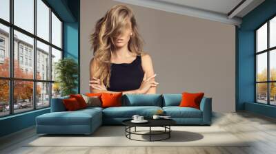 Blond woman with long curly beautiful hair. Wall mural