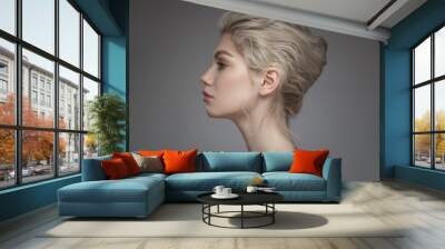 Fashion portrait of a beautiful girl with a bun hairstyle. Gray background. Wall mural