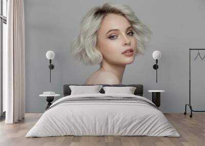 Portrait of a beautiful blonde girl with a short haircut. Gray background. Wall mural