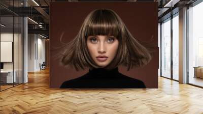 Portrait of a beautiful brown-haired woman with a short haircut on a brown background Wall mural