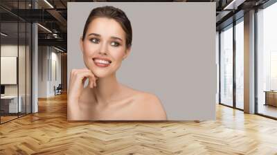 Portrait of young woman. Perfect clean skin and beautiful smile. Gray background. Wall mural