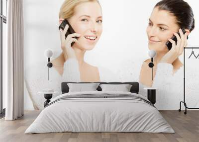 young smiling women with smartphones Wall mural