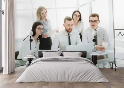 business people working and communicating while sitting at the office desk Wall mural