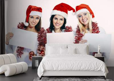 group of female students in costumes of Santa Claus holding blank sheets Wall mural