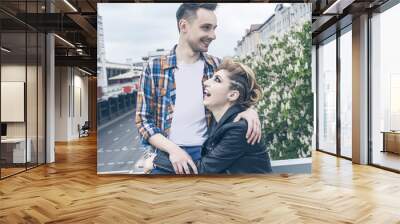 portrait of loving couple standing on bridge in big city Wall mural