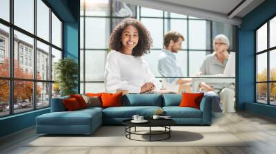 smiling business woman sitting in her office. Wall mural