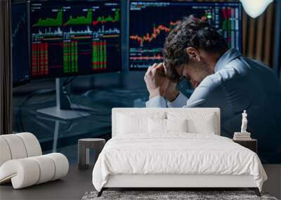 worried young investor sitting at a computer desk . Wall mural