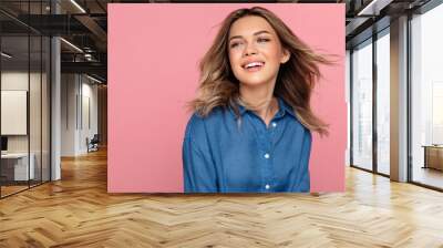 Carefree tender young woman happy smiling with perfect white smile dreamy looking wear denim jeans shirt isolated over pink wall. Studio portrait of charming blonde casual girl with natural makeup Wall mural