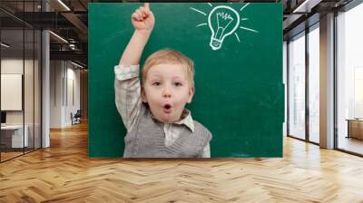 Cheerful smiling child at the blackboard. Wall mural