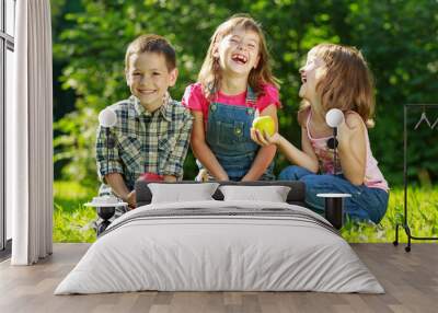 three happy smiling child playing in park Wall mural