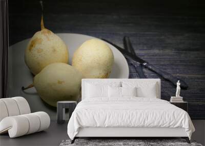 Fresh yellow Chinese pears and two knives on a dark wooden table. Selective focus. Food sweet background Wall mural