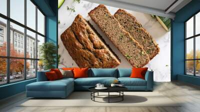 A top-down view of freshly baked and sliced zucchini bread on a white granite countertop. Wall mural