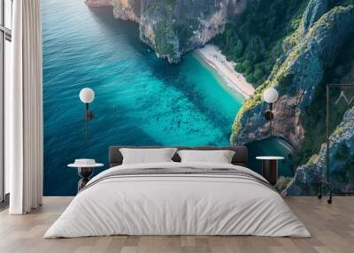 An aerial view of a stunning nature background featuring an azure beach with rocky mountains and clear blue water, showcasing the vibrant and bright colors of the Thailand ocean on a sunny day. Wall mural