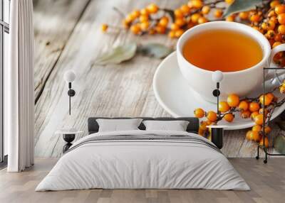 Fresh sea buckthorn berries and a cup of sea buckthorn tea on a white wooden table. Wall mural