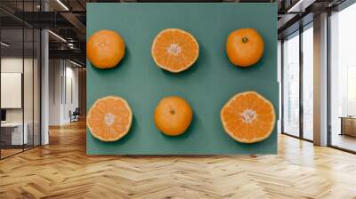 Fruit pattern of fresh mandarin slices on blue background. Flat lay, top view. Pop art design, creative summer concept. Half of citrus in minimal style. Tangerine. Wall mural