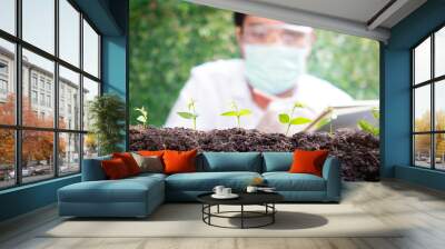 Select focus Seedling over blurred Smart Farmers t Wall mural