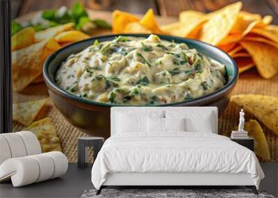 Creamy cheesy spinach artichoke dip with tortilla chips on table Wall mural