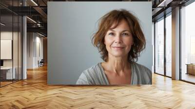 Portrait of beautiful happy middle aged woman looking at camera on white background Wall mural