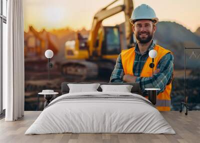 Portrait of happy professional excavator driver standing in front of big excavator looking at camera at sunrise Wall mural