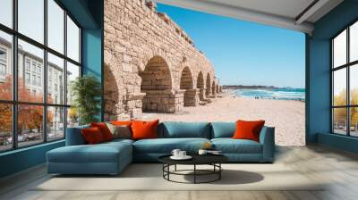 ancient roman aquaduct leading to bright blue ocean Wall mural