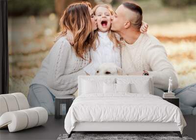 Happy beautiful family with dog labrador is having fun  are sitting on green grass in park. Wall mural