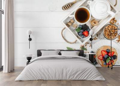 Healthy breakfast with american pancake, granola, fruits, berries on white background. Wall mural