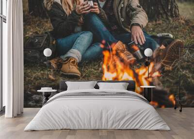 Traveler couple camping in the forest and relaxing near campfire after a hard day. Concept of trekking, adventure and seasonal vacation. Wall mural