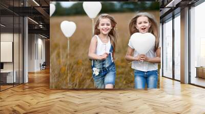 portrait of a little girls in a field with white balloons Wall mural